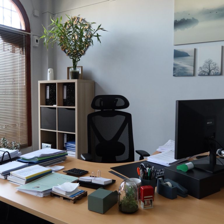 Oficina moderna y ordenada con escritorio, ordenador, carpetas y material de oficina, ideal para tareas administrativas, contables y fiscale