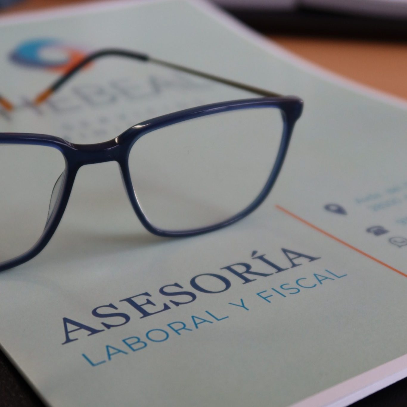 Gafas sobre un documento que dice "ASESORÍA LABORAL Y FISCAL".